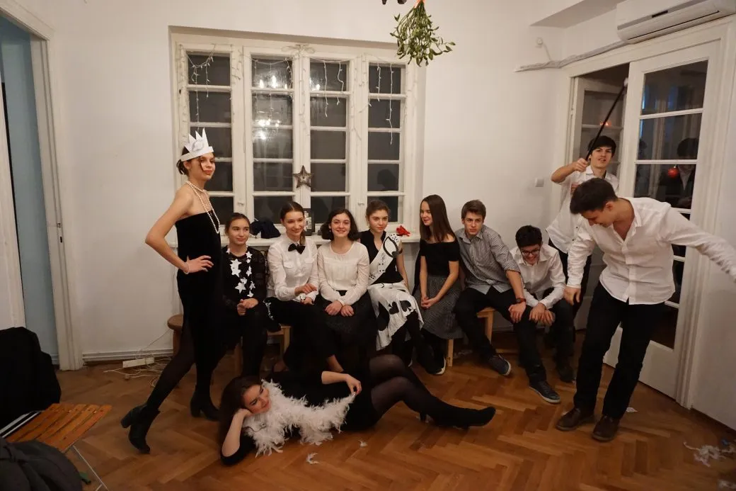 Tineri costumați, râzând, la o seară de grup.